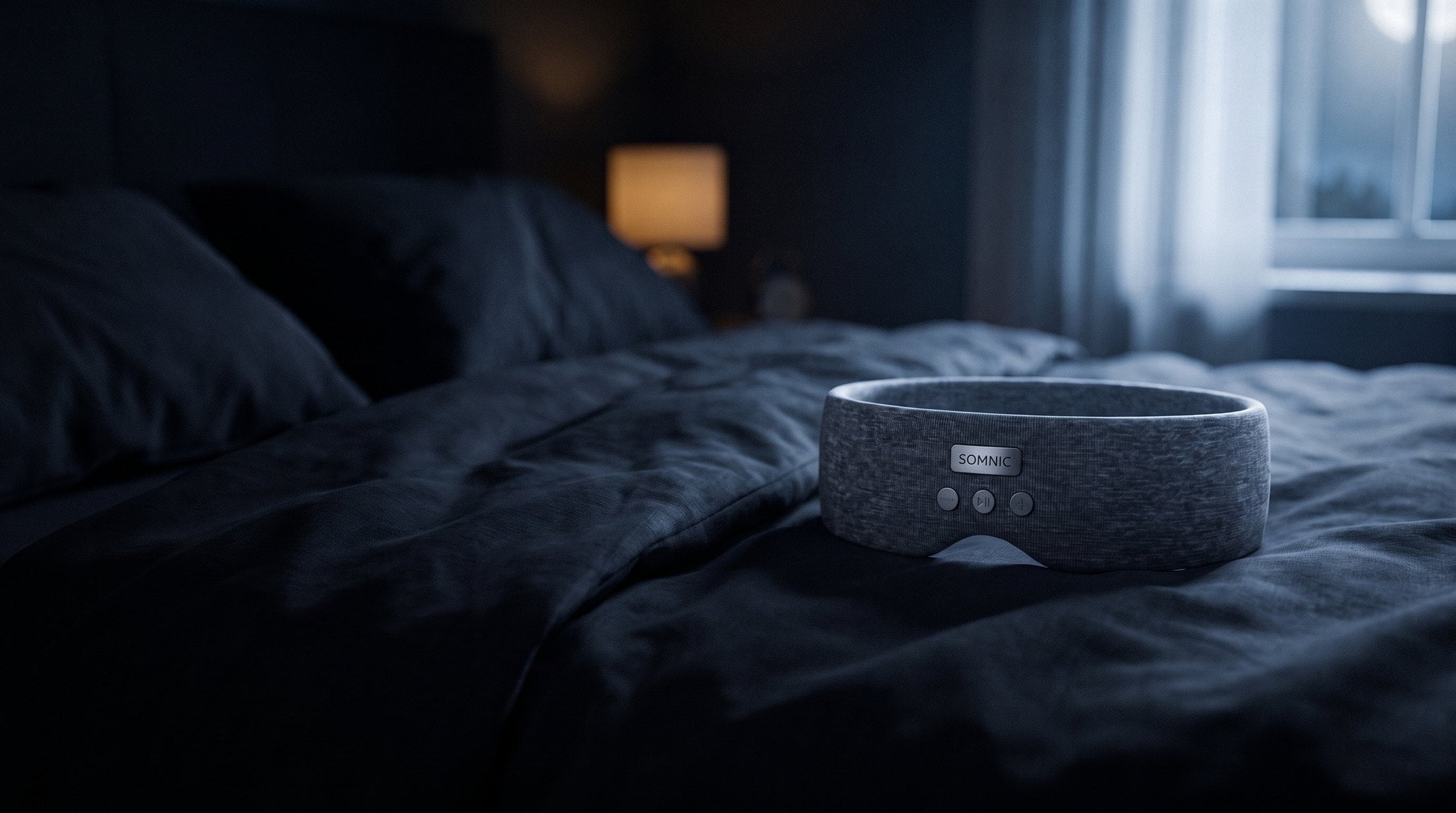 The Somnic Sleep Band resting on a dark bed in a calm, moonlit bedroom
